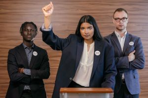 woman in black blazer behind speech desk
