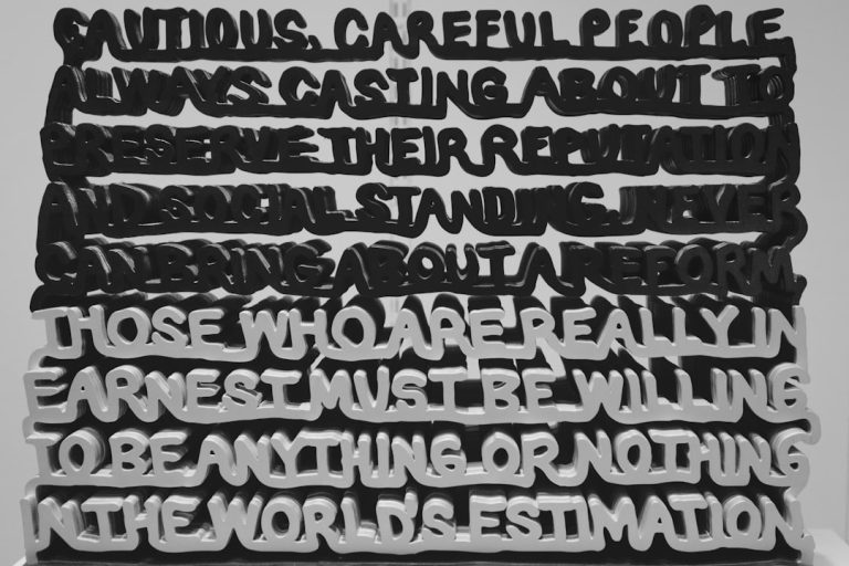 Artwork displays a quote with layered black and white text.