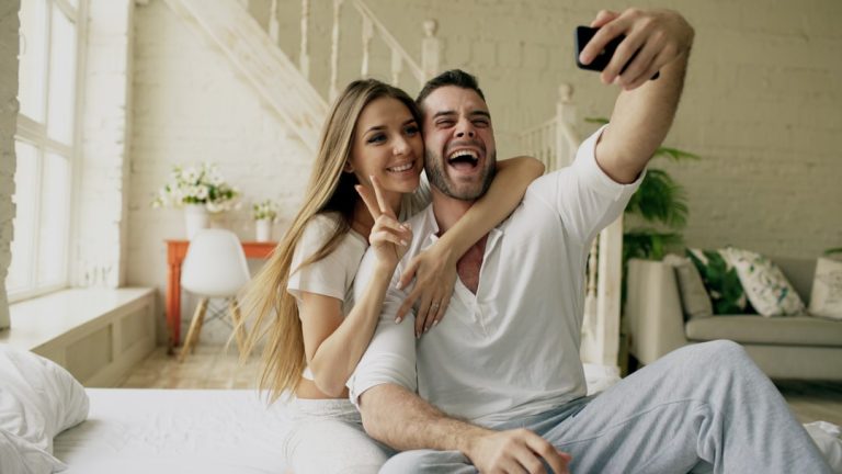 Couple taking a selfie in a bright, modern room