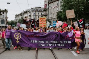 group of people holding purple banner