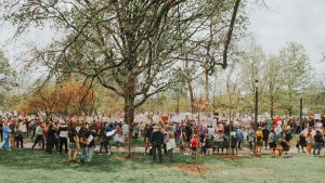 A large crowd of people are gathered in a park