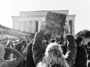 Woman holds sign at protest in front of lincoln memorial