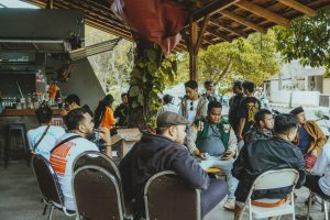 People gather and socialize outdoors at a cafe